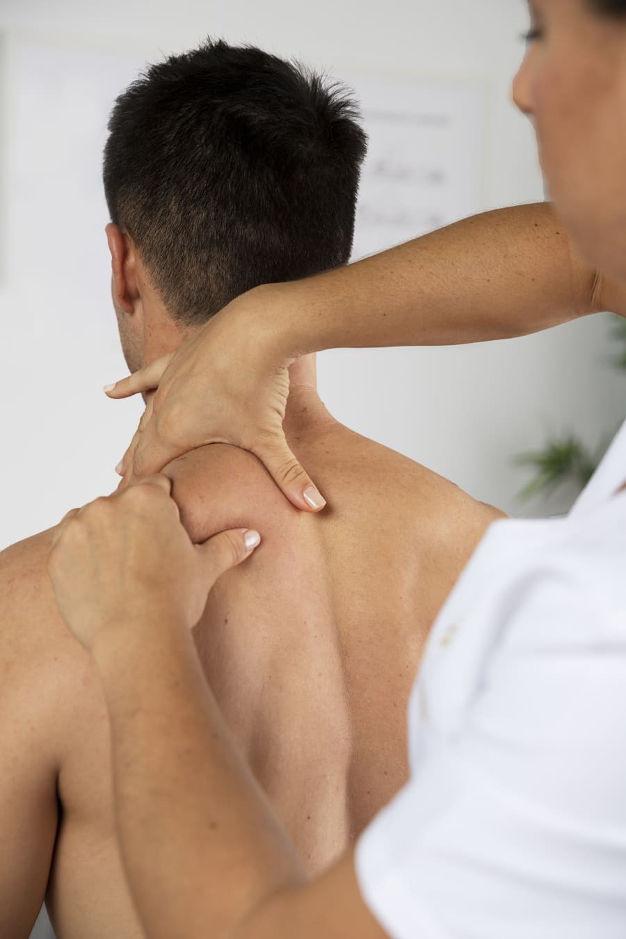 fisioterapeuta realizando masaje terapéutico paciente masculino